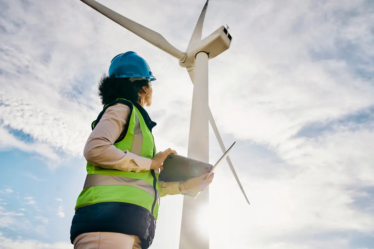 Engineer with laptop at wind turbine
