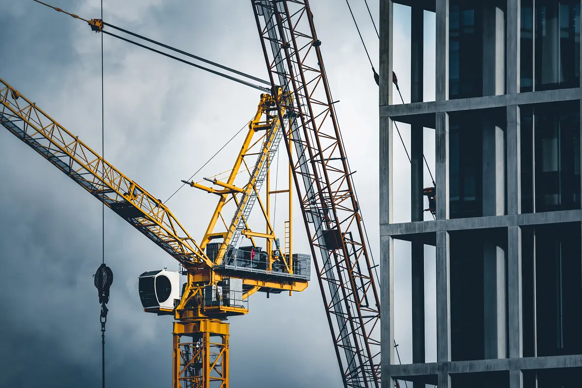 Yellow tower crane at building site